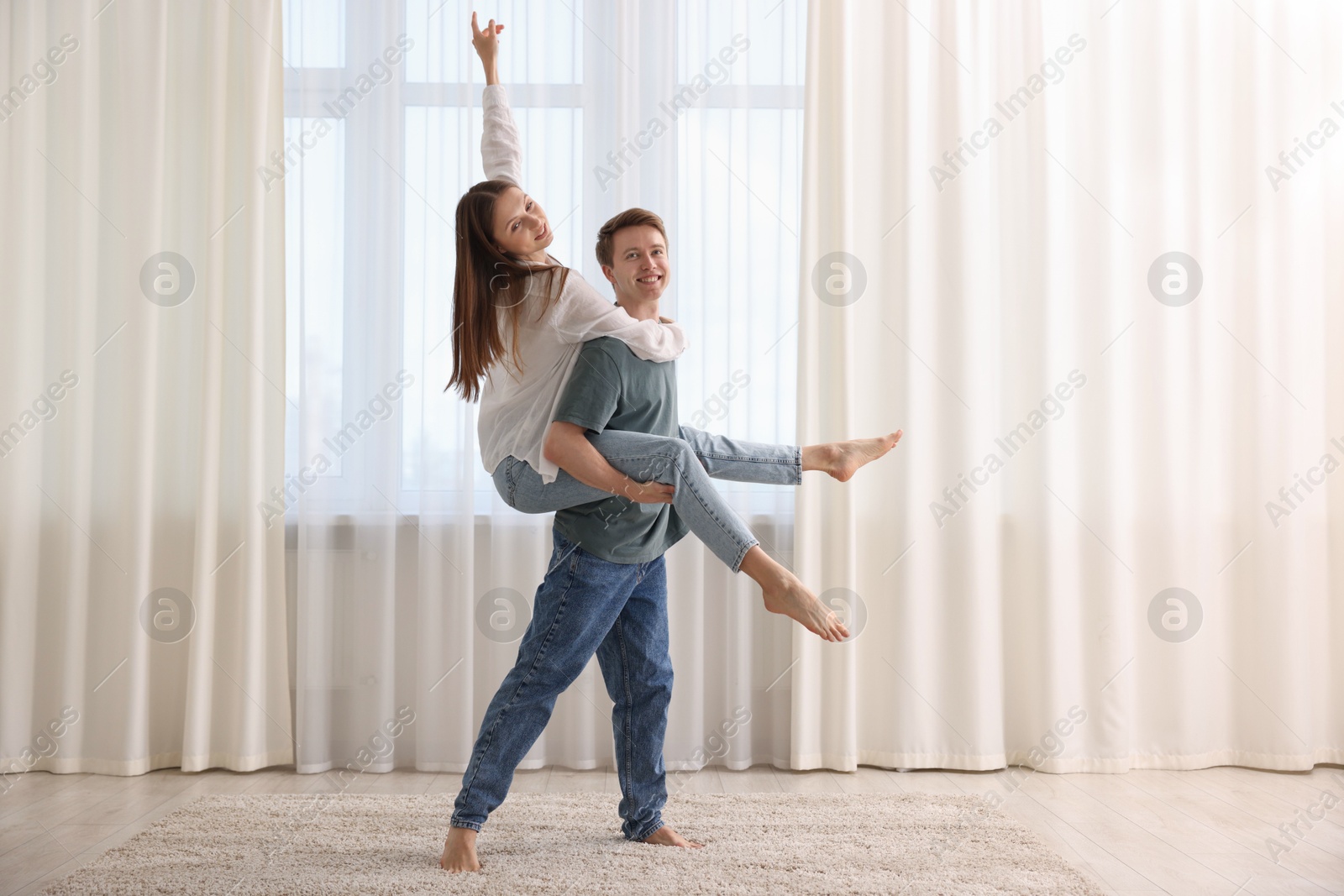 Photo of Happy young couple dancing together at home