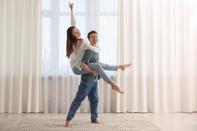 Photo of Happy young couple dancing together at home