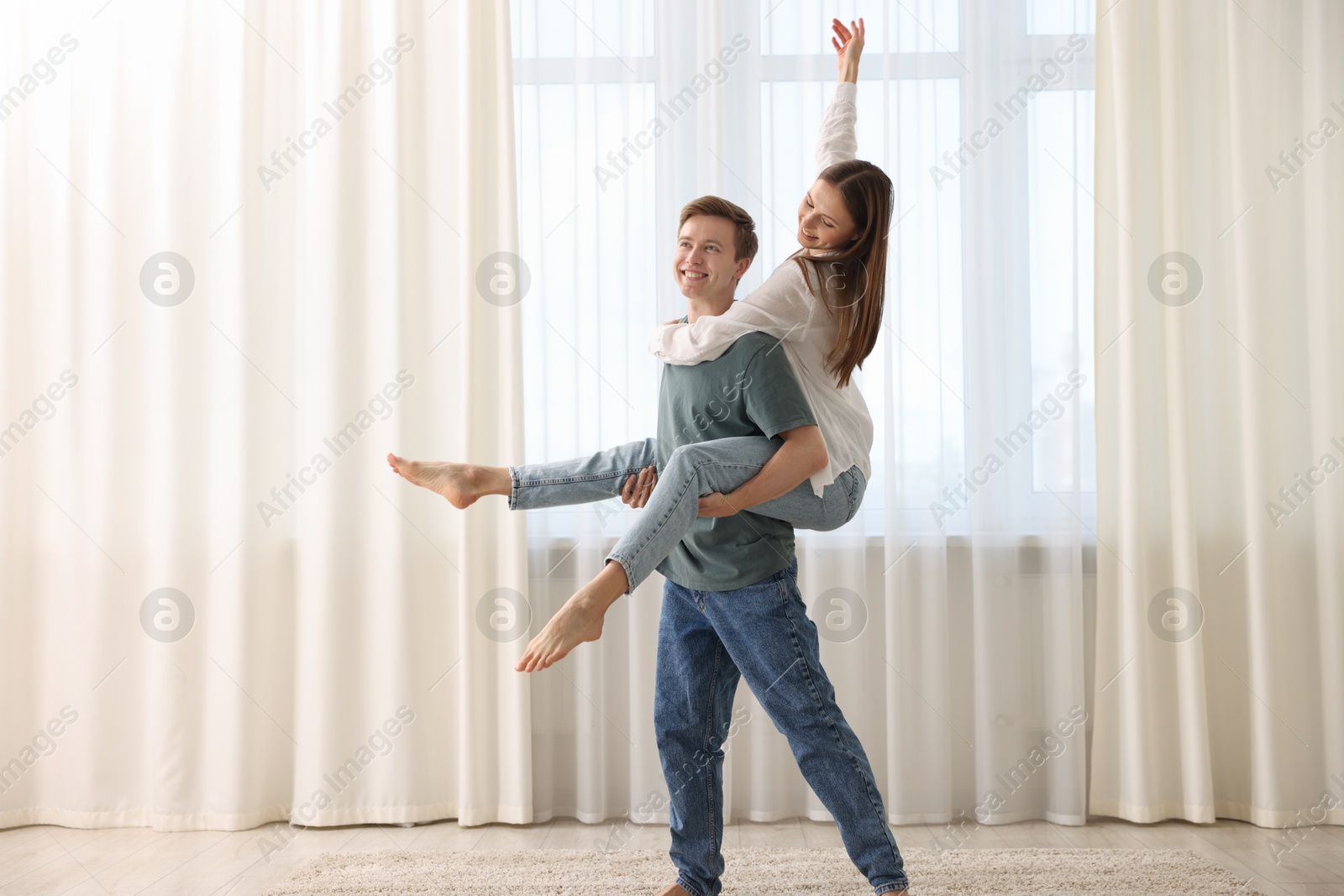 Photo of Happy young couple dancing together at home