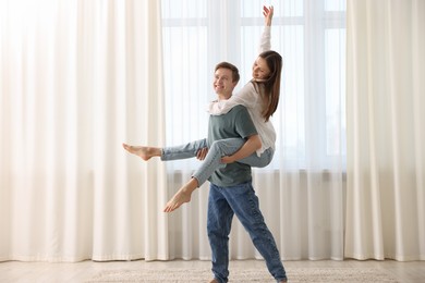 Photo of Happy young couple dancing together at home