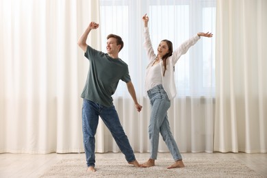 Photo of Happy young couple dancing together at home