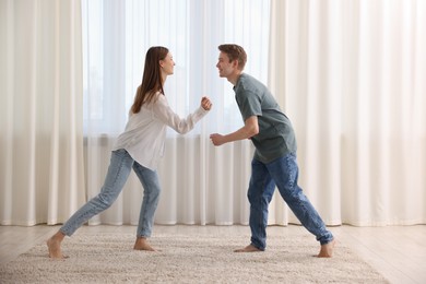 Photo of Happy young couple dancing together at home