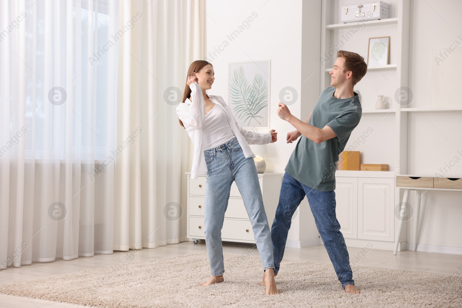 Happy young couple dancing together at home Photo of Happy young couple dancing together at home