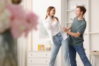 Photo of Happy young couple dancing together at home