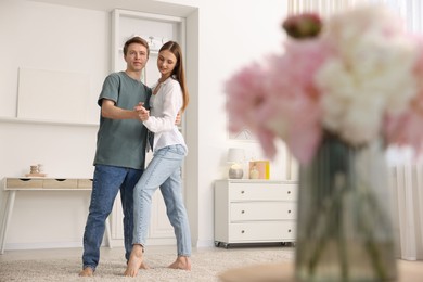 Photo of Happy young couple dancing together at home, low angle view