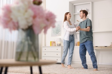 Photo of Happy young couple dancing together at home, low angle view
