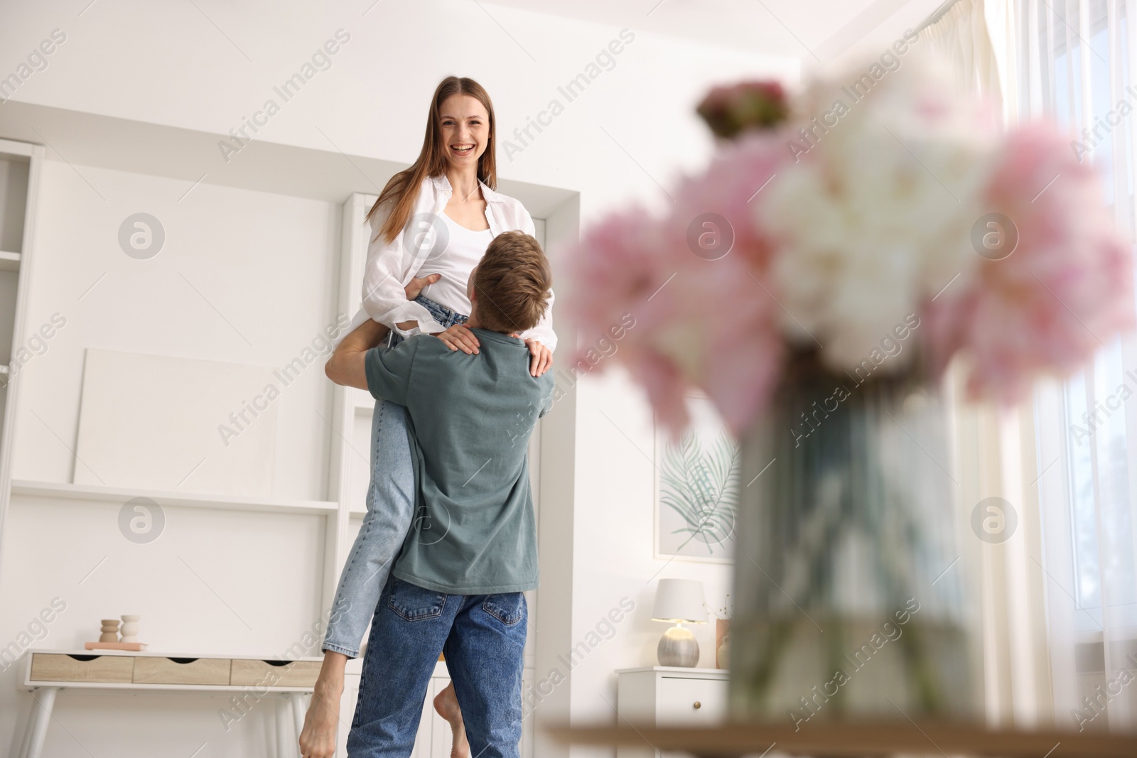 Happy young couple dancing together at home, low angle view Photo of Happy young couple dancing together at home, low angle view