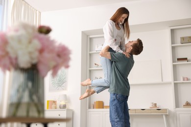 Photo of Happy young couple dancing together at home, low angle view