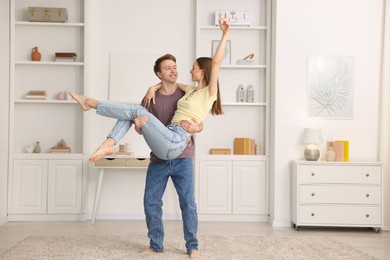 Photo of Happy young couple dancing together at home