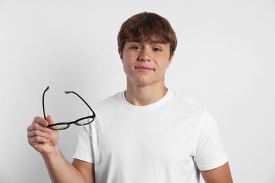 Photo of Portrait of cute teenage boy with glasses on light grey background