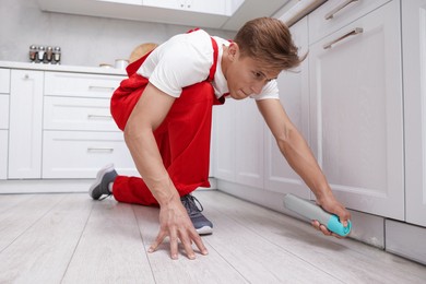 Photo of Pest control worker spraying insecticide at home