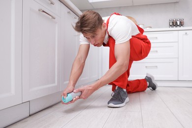 Photo of Pest control worker spraying insecticide at home