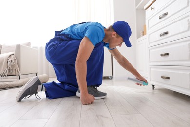 Photo of Pest control worker spraying insecticide at home