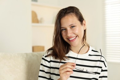Photo of Smiling teenage girl with glasses at home. Space for text