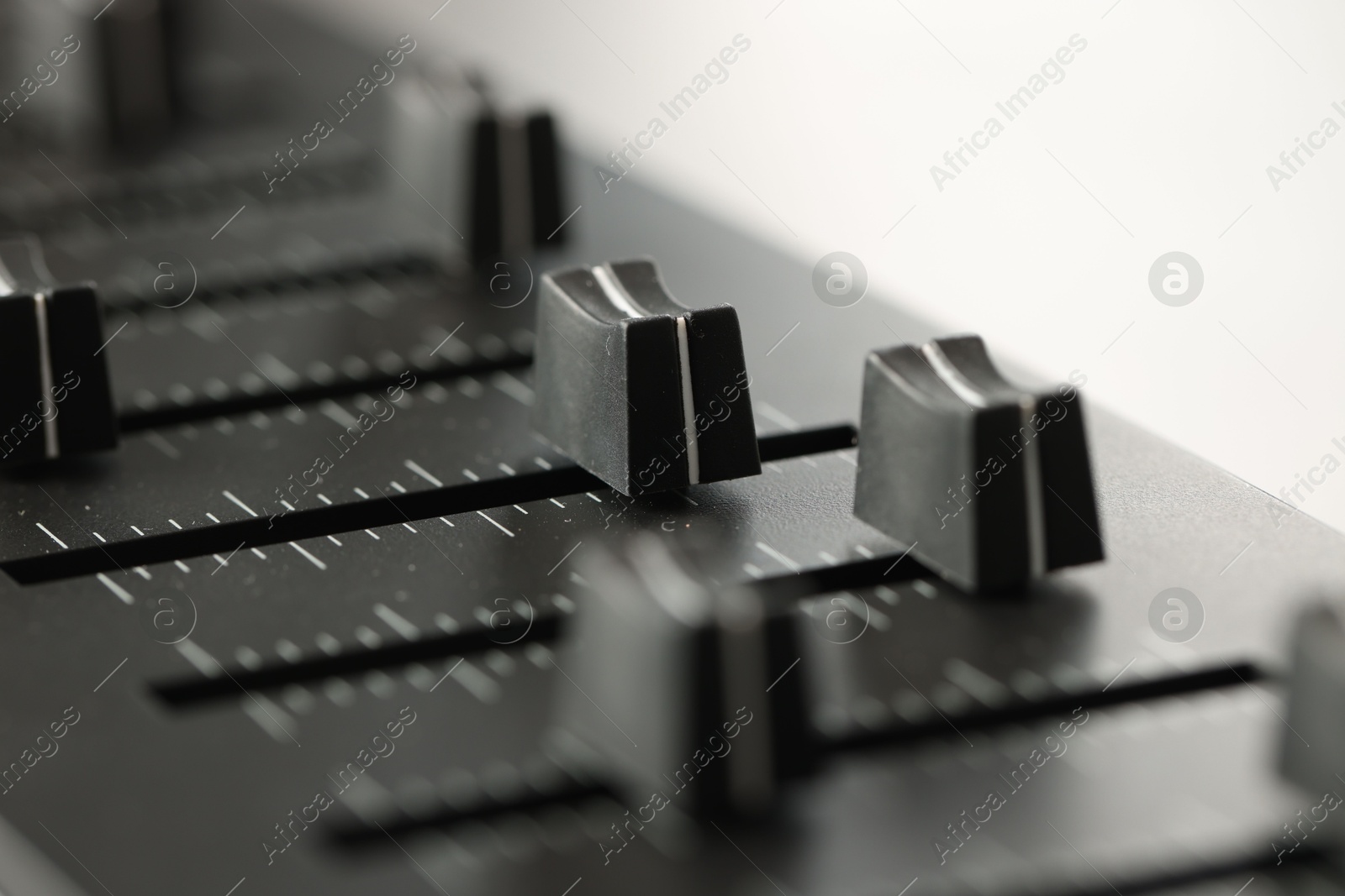 MIDI keyboard with faders on light background, closeup Photo of MIDI keyboard with faders on light background, closeup