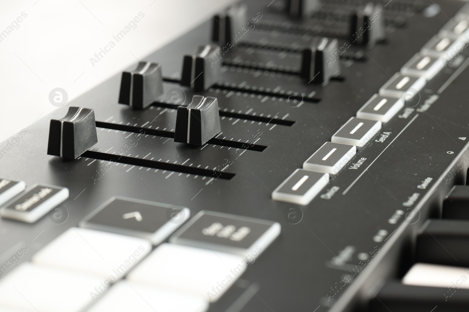 MIDI keyboard with faders on light background, closeup Photo of MIDI keyboard with faders on light background, closeup