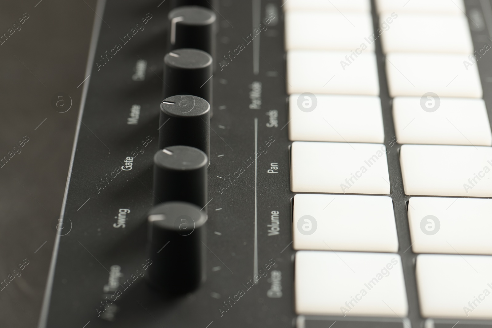 MIDI keyboard with buttons and faders on table, closeup Photo of MIDI keyboard with buttons and faders on table, closeup