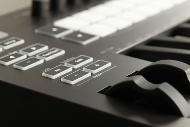 Photo of MIDI keyboard with buttons and faders, closeup