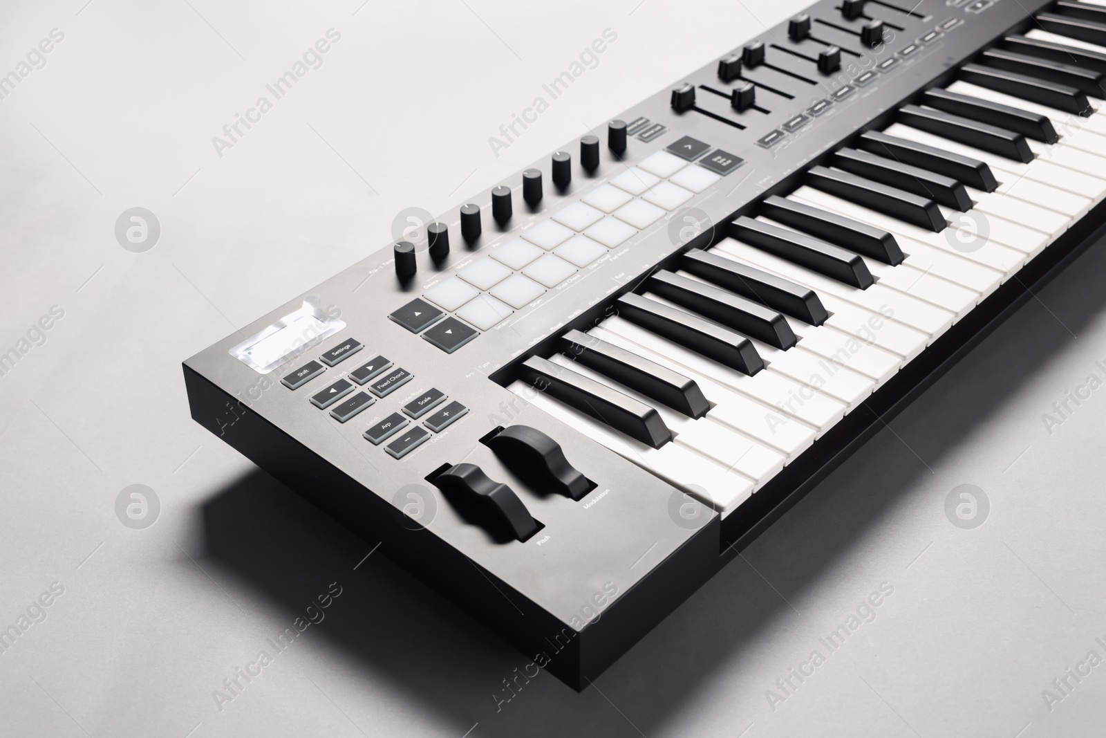 Photo of One portable MIDI keyboard on grey background, closeup