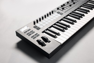 Photo of One portable MIDI keyboard on grey background, closeup