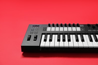 Photo of One portable MIDI keyboard on red background, closeup