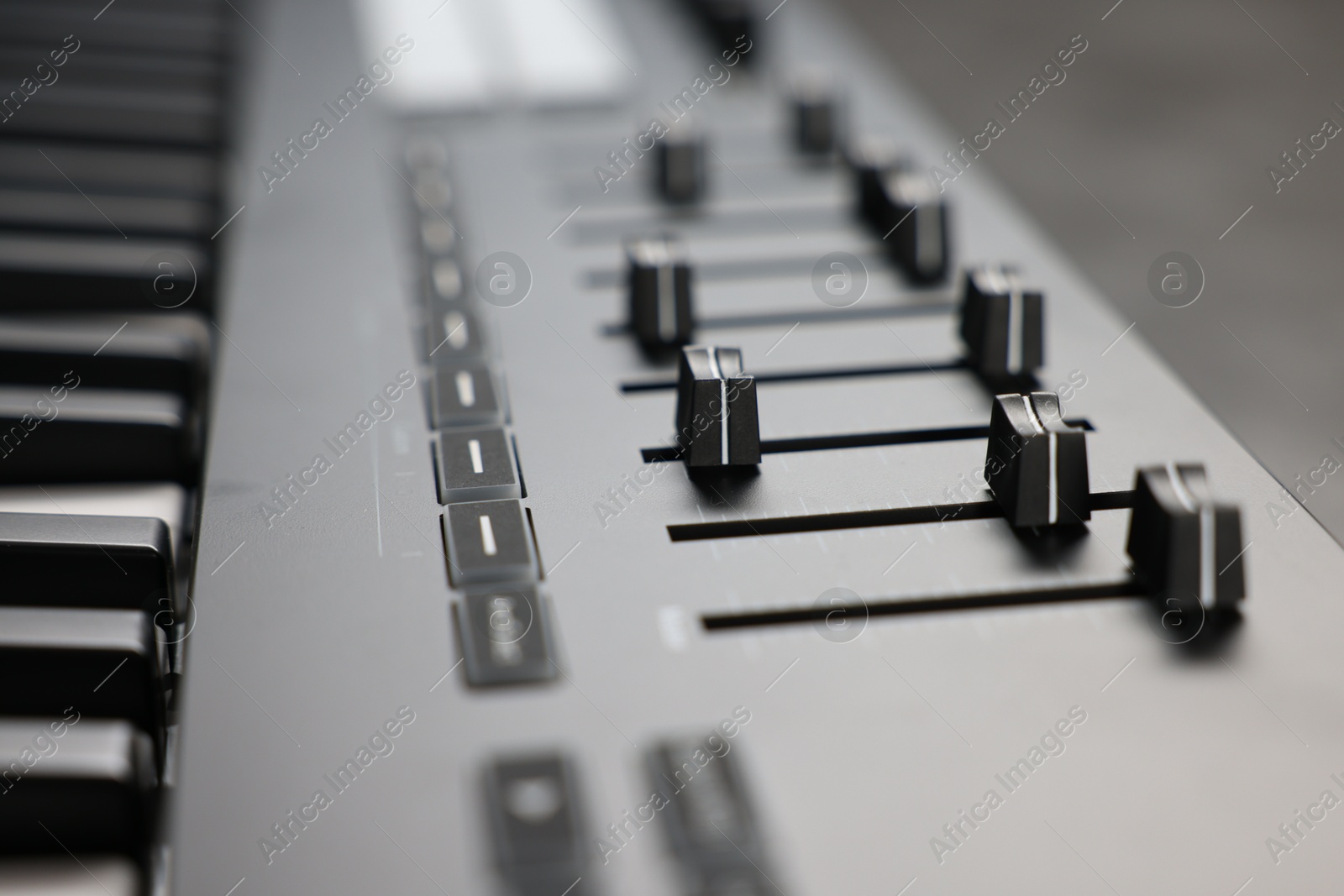 MIDI keyboard with faders on table, closeup Photo of MIDI keyboard with faders on table, closeup
