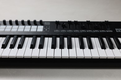 Photo of One portable MIDI keyboard on white table, closeup