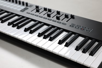 Photo of One portable MIDI keyboard on white table, closeup