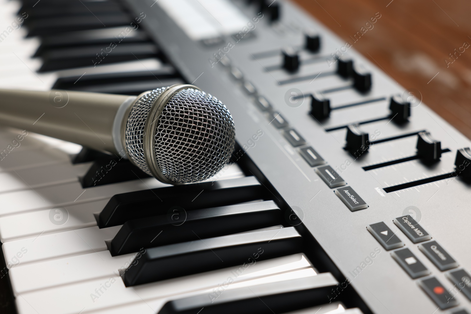MIDI keyboard and microphone on table, closeup Photo of MIDI keyboard and microphone on table, closeup