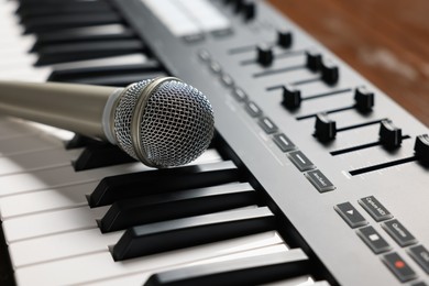 Photo of MIDI keyboard and microphone on table, closeup