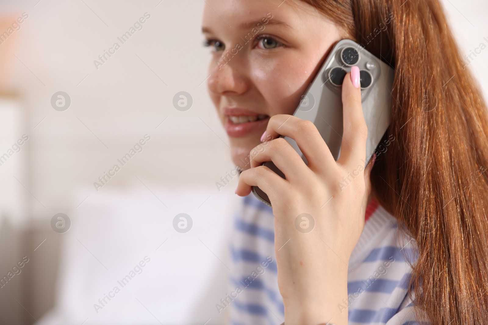 Smiling teenage girl talking by smartphone at home, closeup. Space for text Photo of Smiling teenage girl talking by smartphone at home, closeup. Space for text