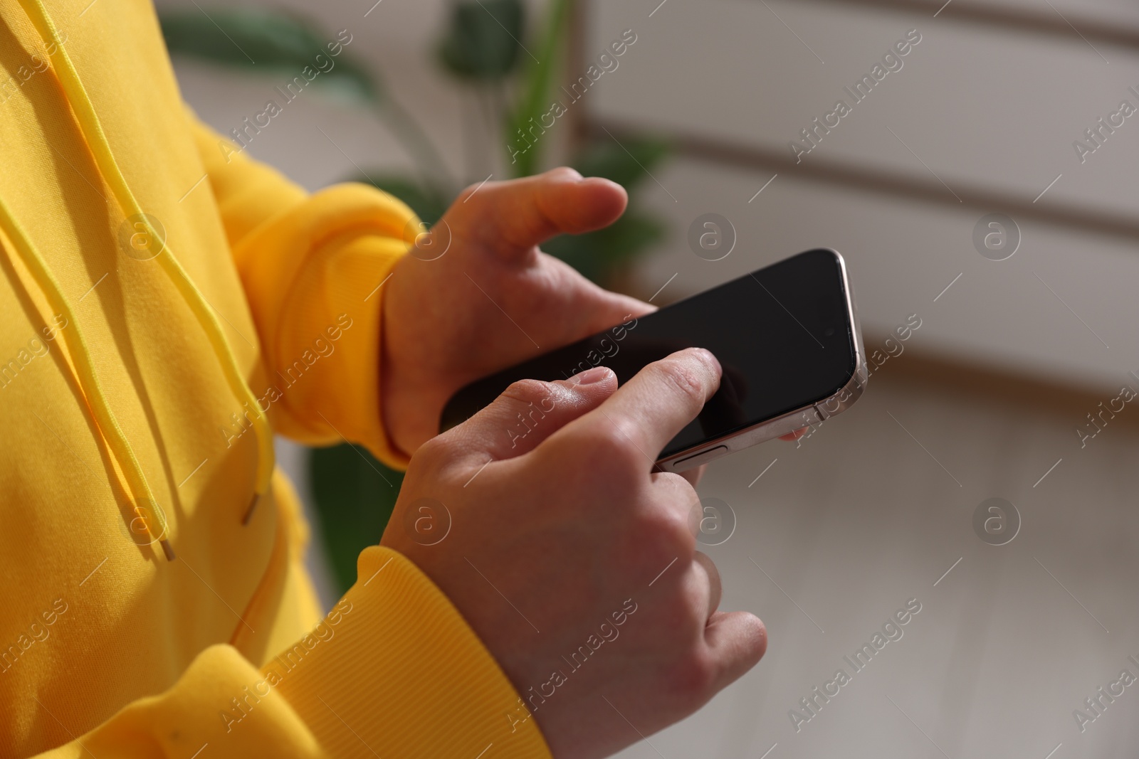 Teenage boy using smartphone at home, closeup Photo of Teenage boy using smartphone at home, closeup