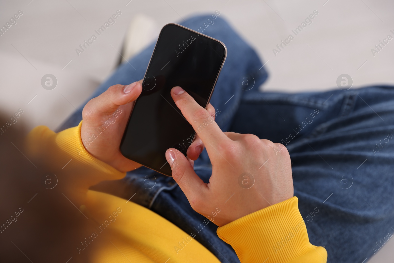 Teenage boy using smartphone at home, closeup Photo of Teenage boy using smartphone at home, closeup
