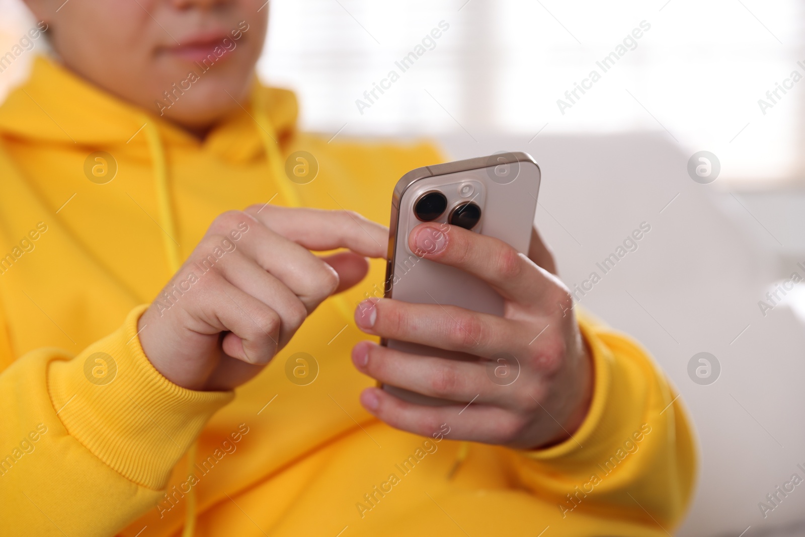 Teenage boy using smartphone at home, closeup Photo of Teenage boy using smartphone at home, closeup