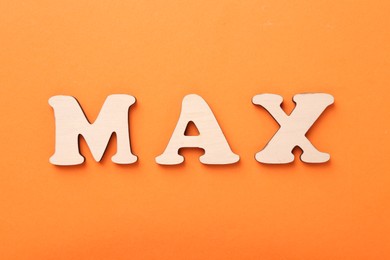 Photo of Word Max made of wooden letters on orange background, top view