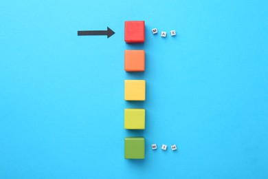 Photo of Words Min and Max, colorful cubes and arrow pointing at red one on light blue background, flat lay
