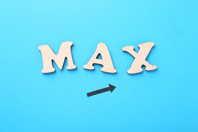 Photo of Word Max made of wooden letters and arrow on light blue background, flat lay
