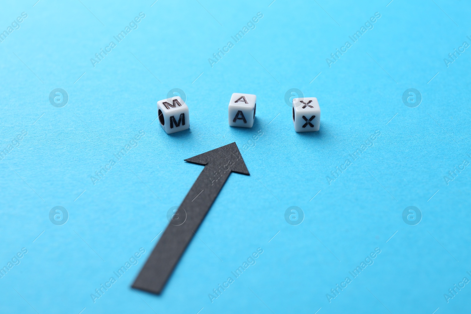 Word Max made of beads with letters and arrow pointing at it on light blue background, closeup Photo of Word Max made of beads with letters and arrow pointing at it on light blue background, closeup