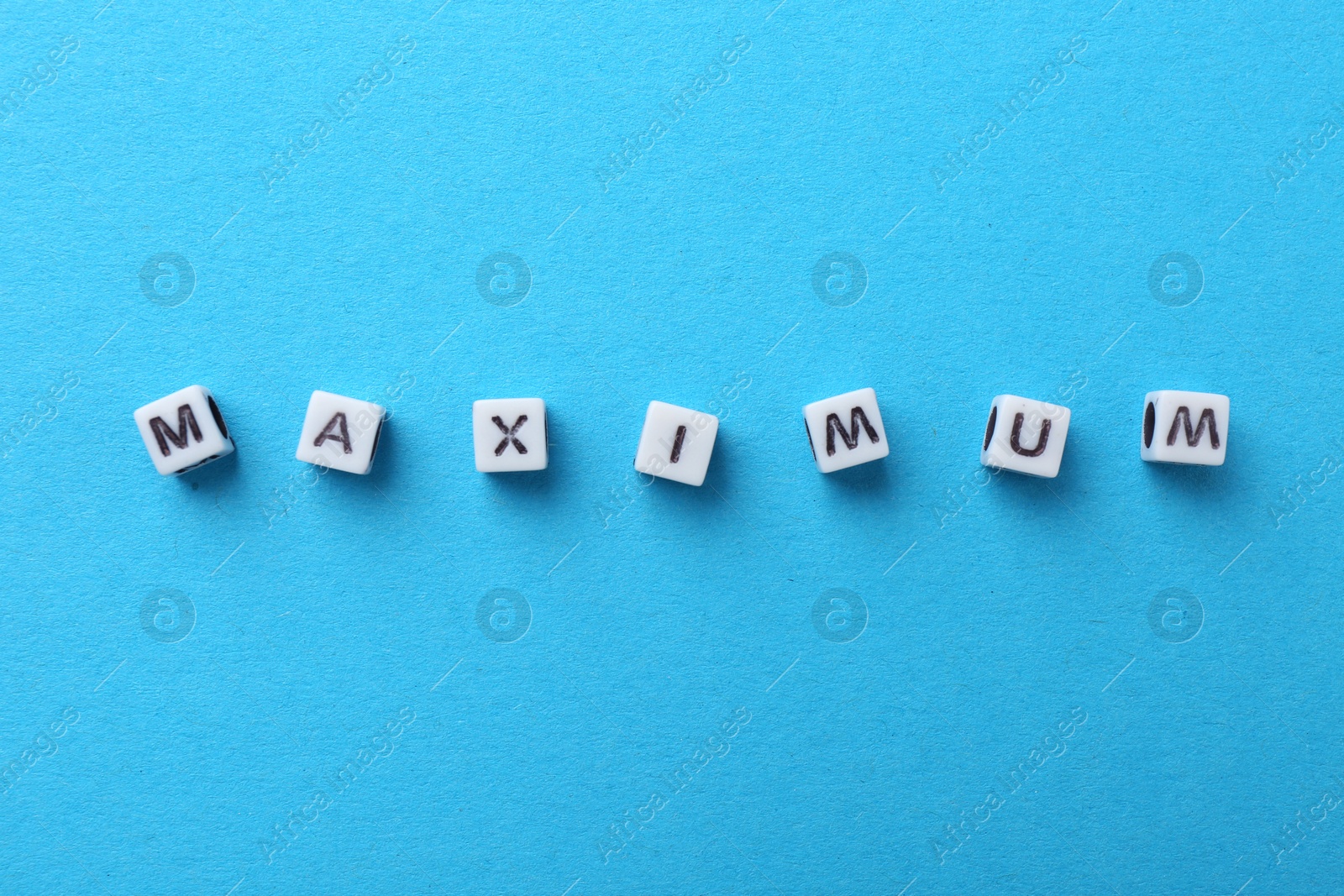Word Maximum made of beads with letters on light blue background, top view Photo of Word Maximum made of beads with letters on light blue background, top view