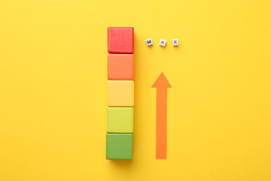 Photo of Colorful cubes and arrow pointing at word Max made of beads with letters on yellow background, flat lay