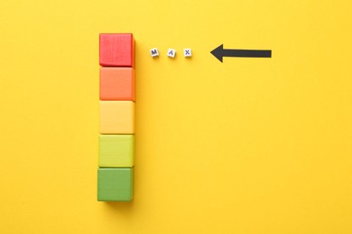 Photo of Colorful cubes and arrow pointing at word Max made of beads with letters on yellow background, flat lay