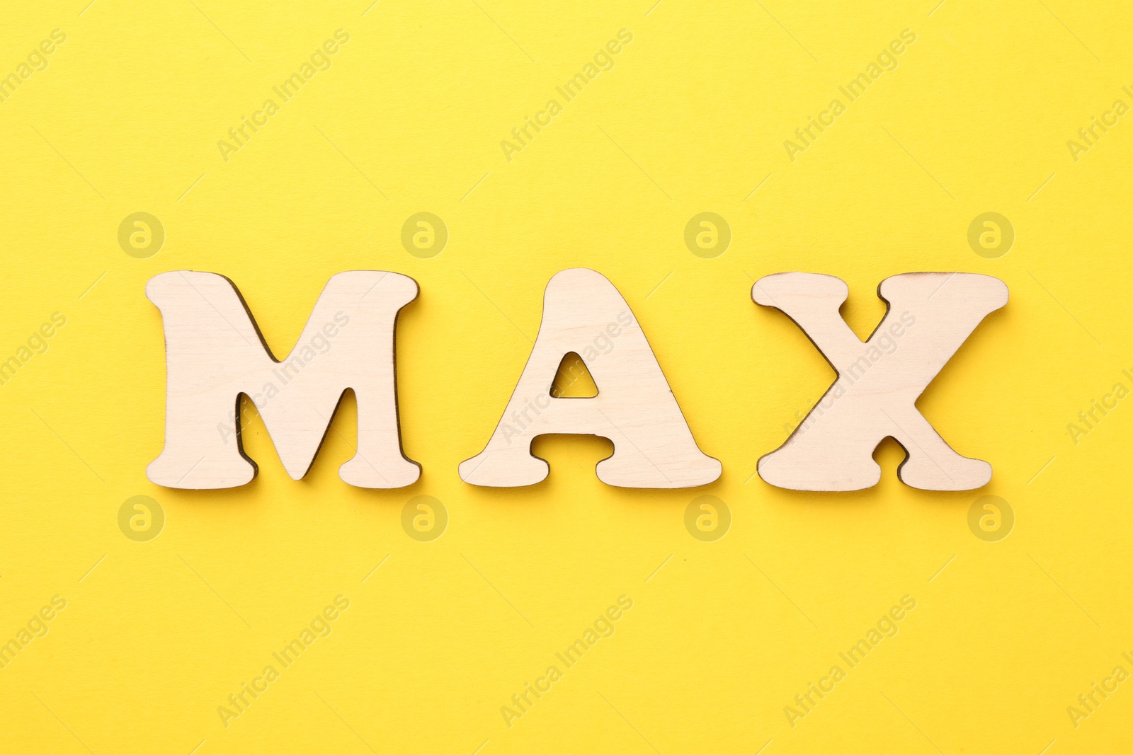 Word Max made of wooden letters on yellow background, top view Photo of Word Max made of wooden letters on yellow background, top view