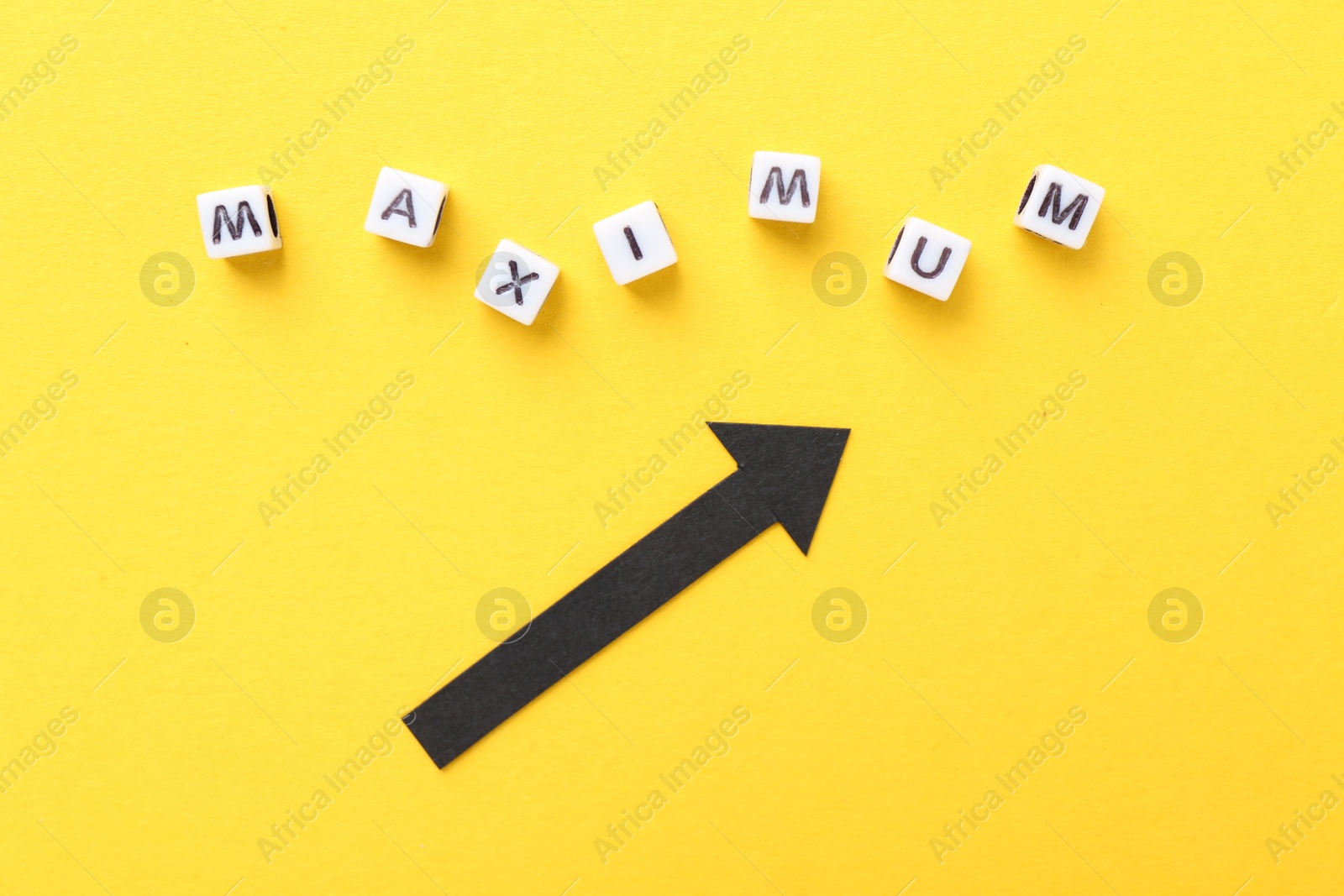 Word Maximum made of beads with letters and arrow pointing at it on yellow background, flat lay Photo of Word Maximum made of beads with letters and arrow pointing at it on yellow background, flat lay