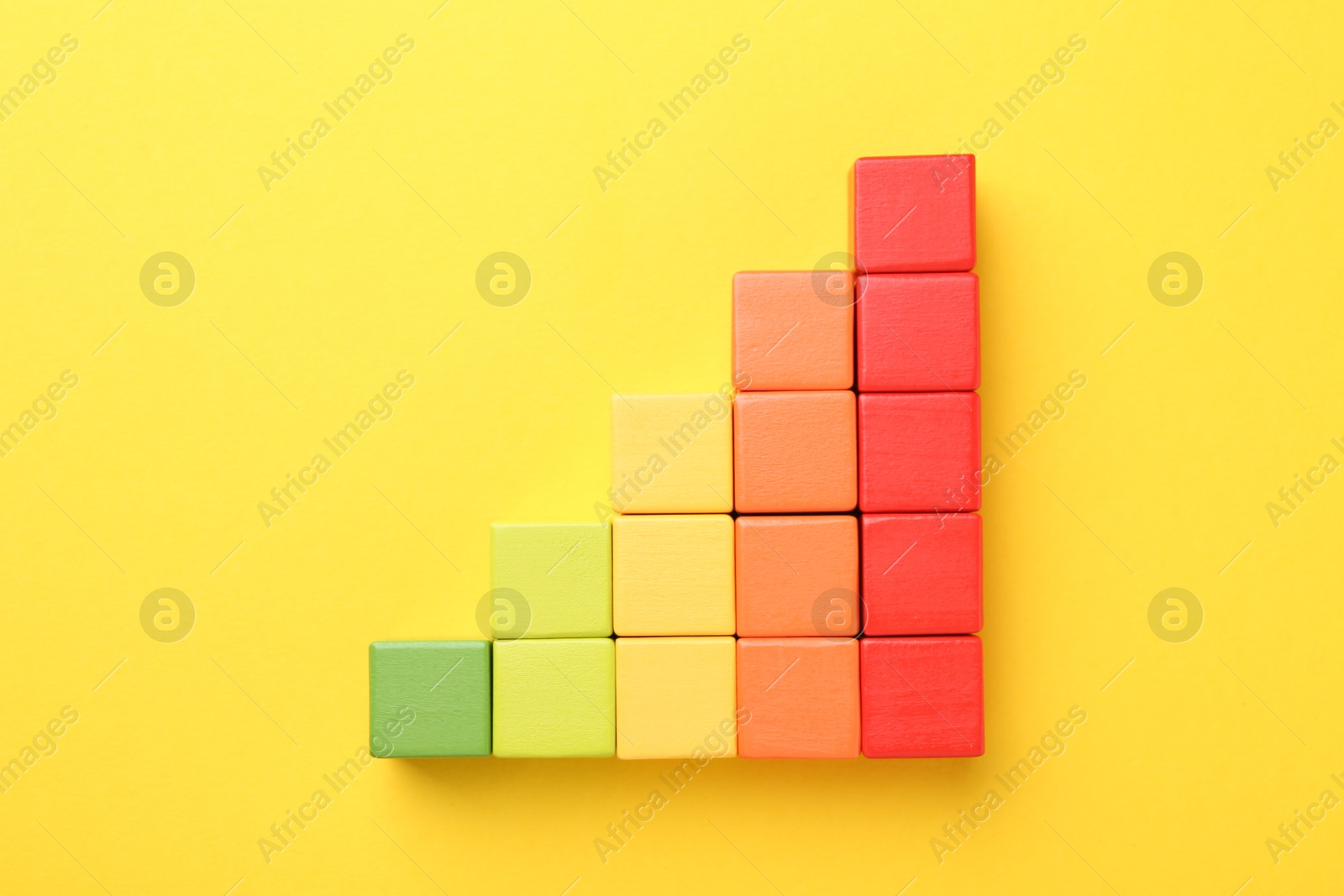 Maximum. Colorful cubes on yellow background, flat lay Photo of Maximum. Colorful cubes on yellow background, flat lay