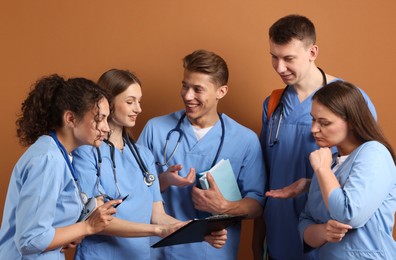 Photo of Group of medical students with books on brown background