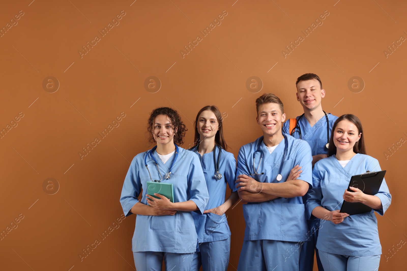 Photo of Group of medical students with books on brown background