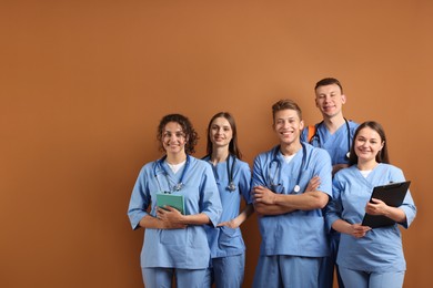 Photo of Group of medical students with books on brown background
