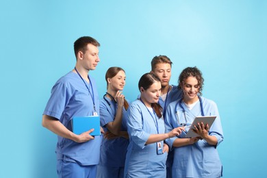 Photo of Group of medical students with tablet on light blue background
