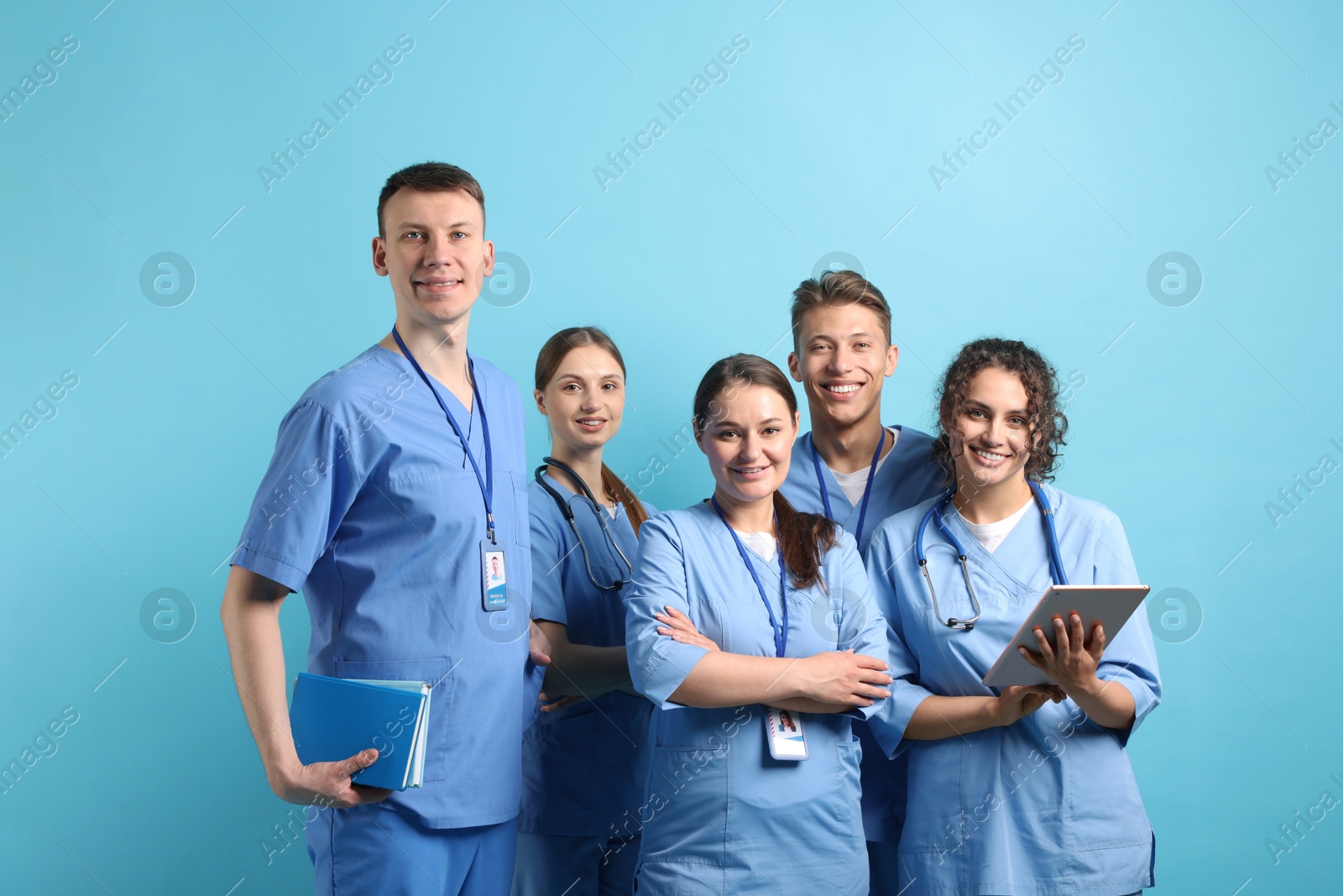 Photo of Group of medical students with tablet on light blue background