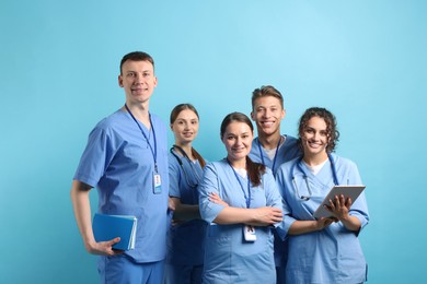 Photo of Group of medical students with tablet on light blue background